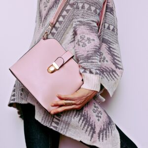 Lady in sweater ornaments and fashion accessories. Bag and styli