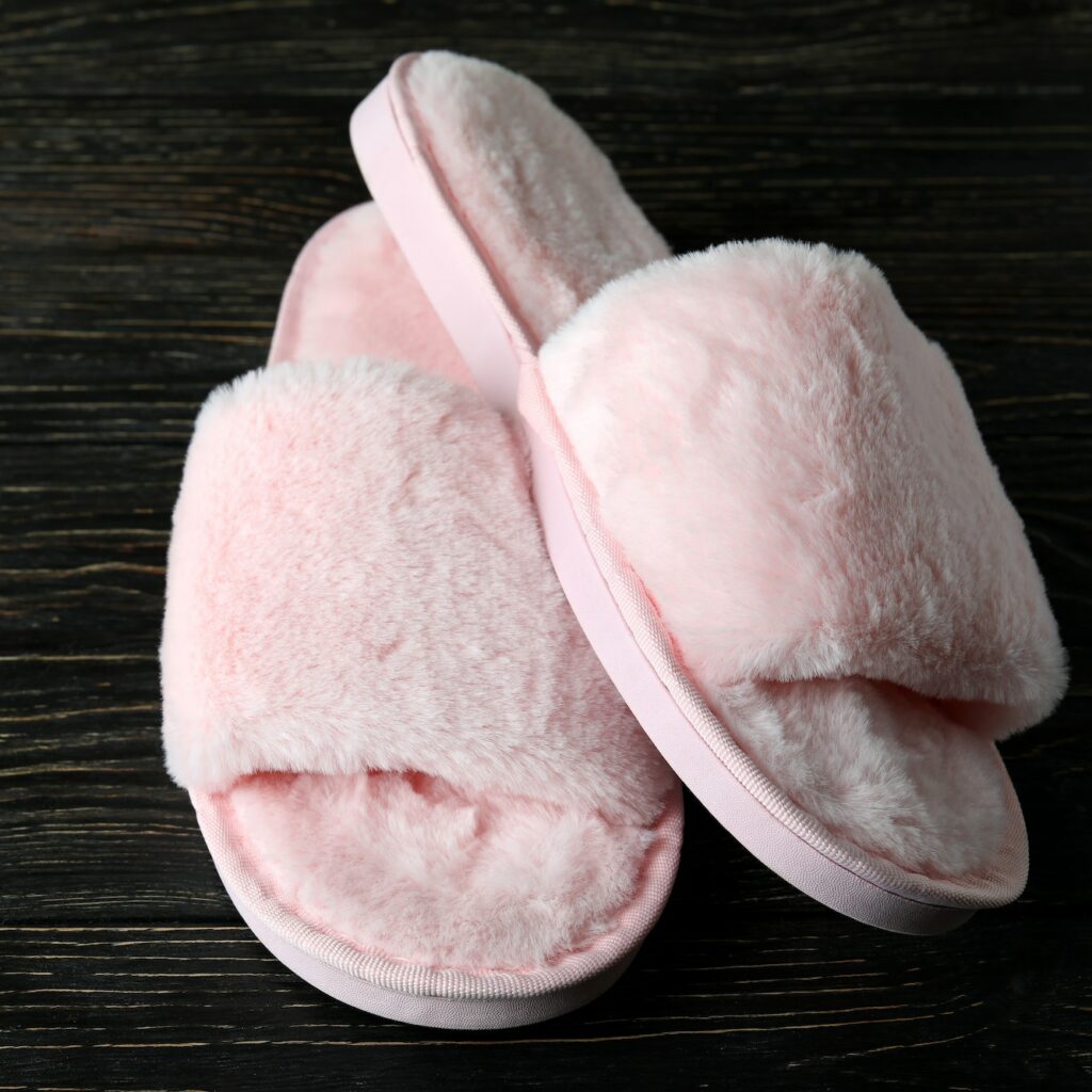 Pair of house slippers on wooden background